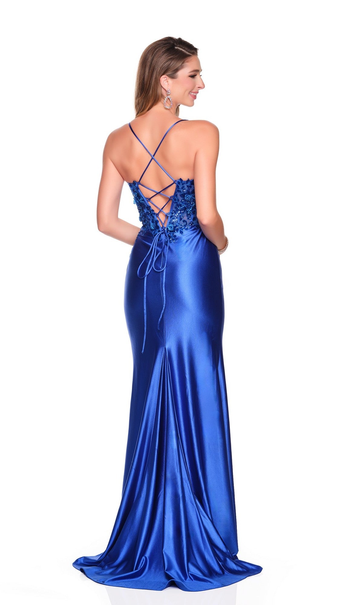 A woman stands with her back to the camera on a white background, wearing the Long Prom Dress: Dave and Johnny 12803—a fitted blue gown with floral sequin appliques, a shiny finish, and lace-up open back.